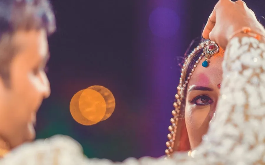 Bridal portrait in profile, shot against candlelight bokeh at the reception