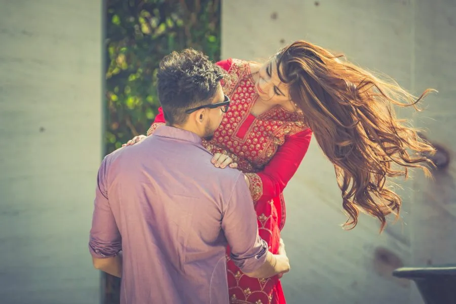Candid pre-wedding portrait of a couple embracing, the bride’s hair caught in motion