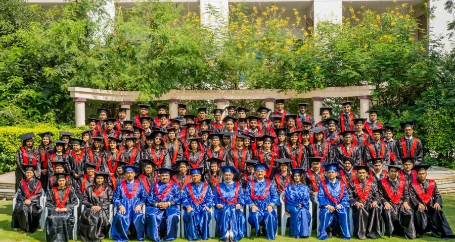 Convocation group photograph of graduating students in robes on a university campus