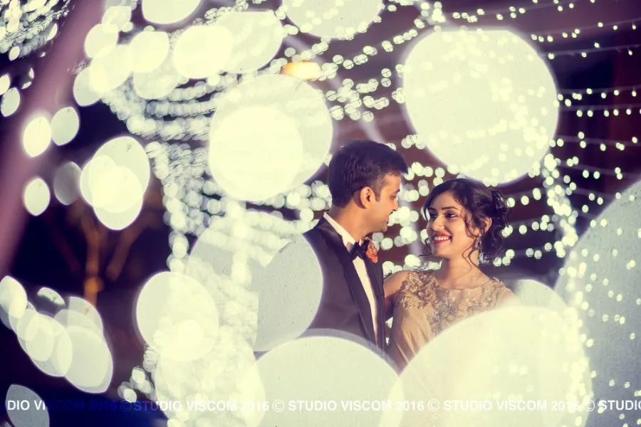 Couple photographed through strings of fairy lights at their wedding reception